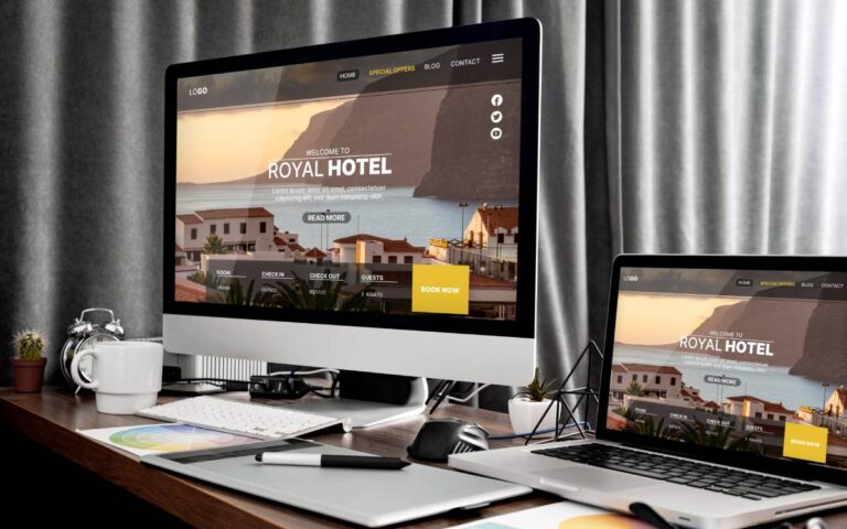 Desenvolvimento de site profissional exibido em um monitor e um laptop com o design do Royal Hotel.