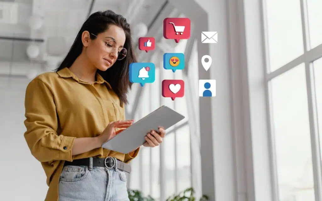 Guia Definitivo 2024: Como Criar um Site Profissional do Zero 3 Mulher usando tablet com ícones de redes sociais flutuando ao redor, representando a integração de redes sociais em sites.