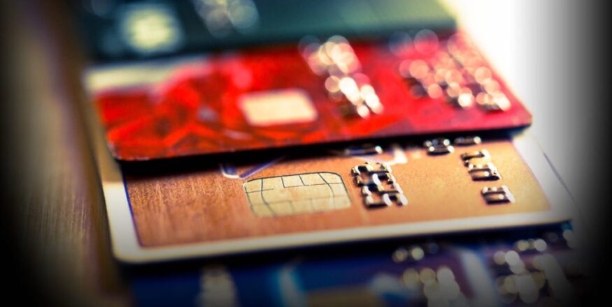 Close-up abstrato de cartões de crédito e débito com dígitos numéricos, simbolizando compras com IA Visa Mastercard e pagamentos digitais.