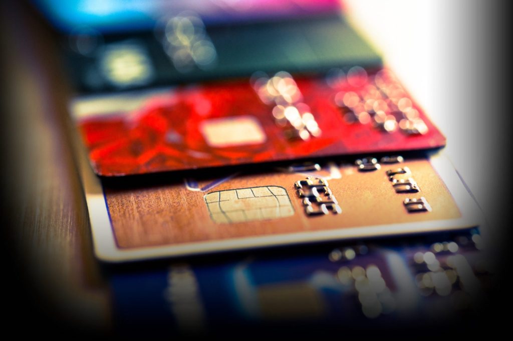 Close-up abstrato de cartões de crédito e débito com dígitos numéricos, simbolizando compras com IA Visa Mastercard e pagamentos digitais.