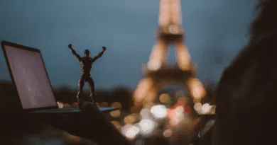 Ilustração de um laptop aberto com código e um robô pequeno sobre a mesa, simbolizando Devstral