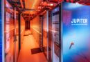 Gabinete azul do supercomputador exascale JUPITER na sala de servidores, destacando refrigeração com luz vermelha