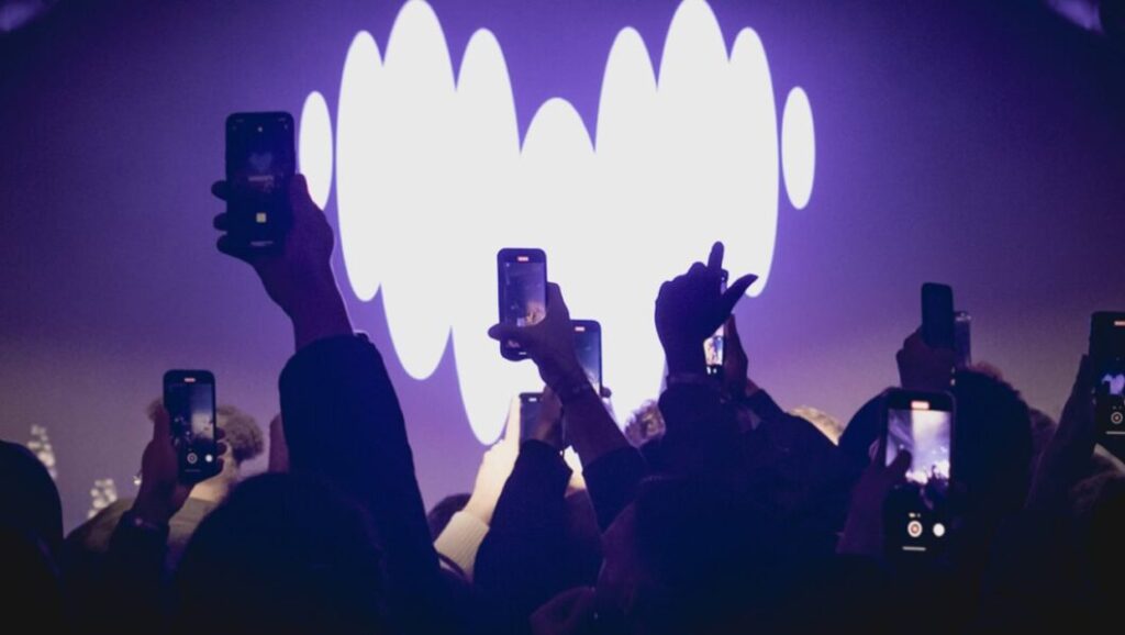 Palco com o logotipo da Deezer ao fundo, simbolizando grandes eventos da música digital; plataforma investe em políticas para valorizar artistas legítimos e proteger o mercado.