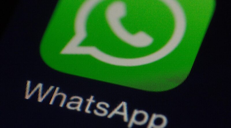 Logo do WhatsApp ao centro, fundo verde com faixas diagonais claras. Balão de diálogo branco com ícone de telefone no centro. Logotipo Tecnoblog no canto inferior direito.