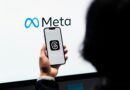Mãos segurando um smartphone com o logotipo da Meta Threads na tela e a marca Meta ao fundo.