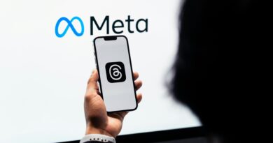 Mãos segurando um smartphone com o logotipo da Meta Threads na tela e a marca Meta ao fundo.