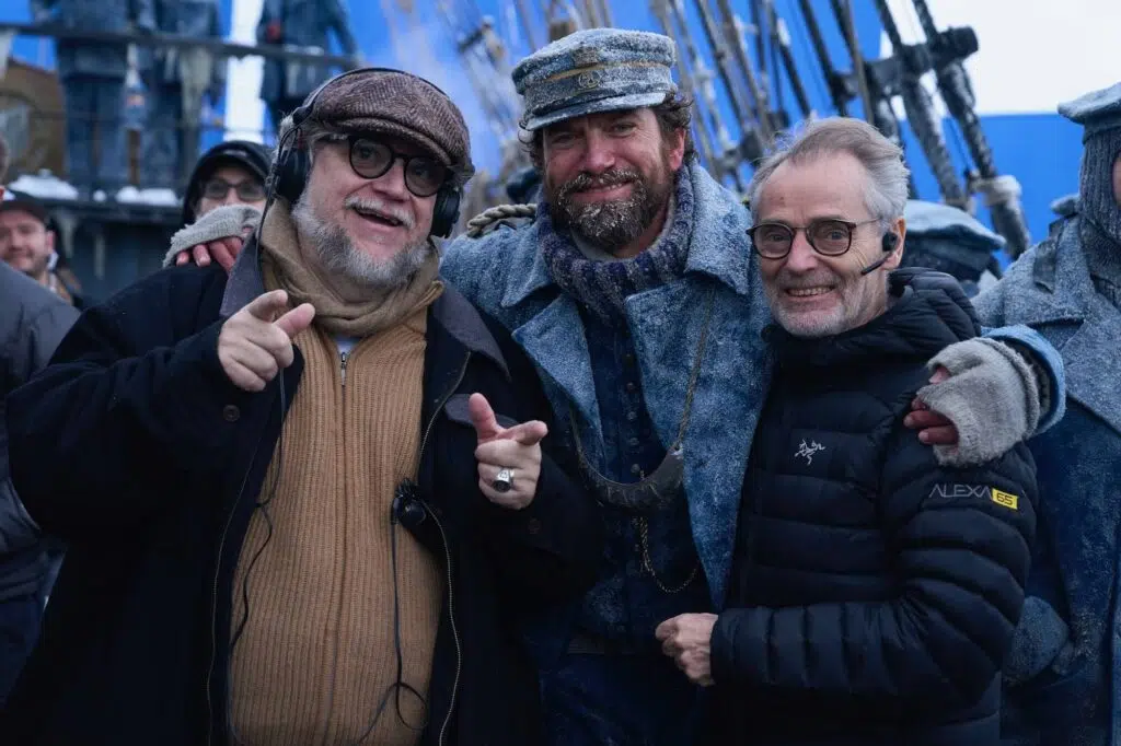 Frankenstein Netflix: tudo sobre o filme de Guillermo del Toro 8 Imagem dos bastidores, equipe técnica filmando Frankenstein em um barco, atmosfera sombria