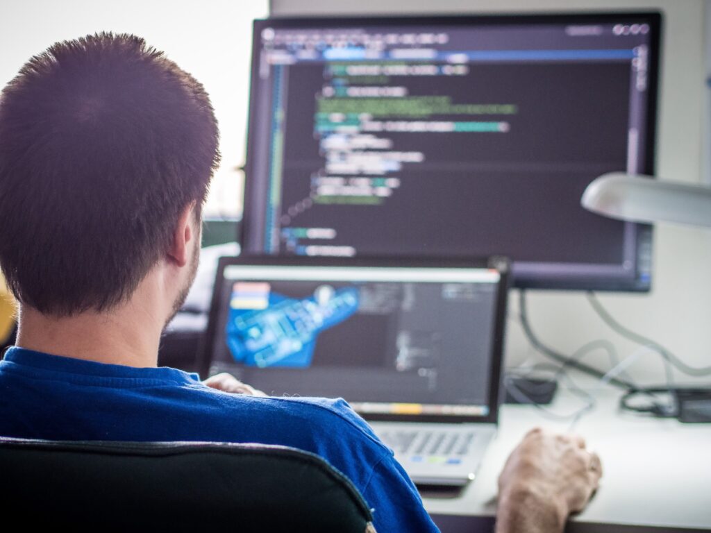 Desenvolvedores usam IA mais, mas confiam menos em 2025 3 Código e telas sendo monitorados por desenvolvedores – IA em ambientes de desenvolvimento