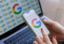 Mulher olha para celular exibindo o logo do Google, com logo do Google em monitor ao fundo; lançamento do Fontes Preferidas em agosto de 2025 nos EUA e Índia.
