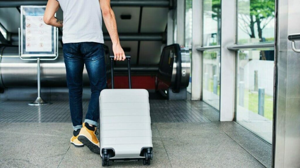 Brasil aprova fim do roaming no Mercosul 3 Pessoa com mala em aeroporto; fim do roaming no Mercosul reduz custos de viagem entre países vizinhos