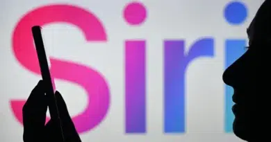Novo Siri da Apple permitirá operar apps só por voz 4 Mulher segura smartphone na frente do logo da Siri em uma tela – Novo Siri da Apple para controle por voz.