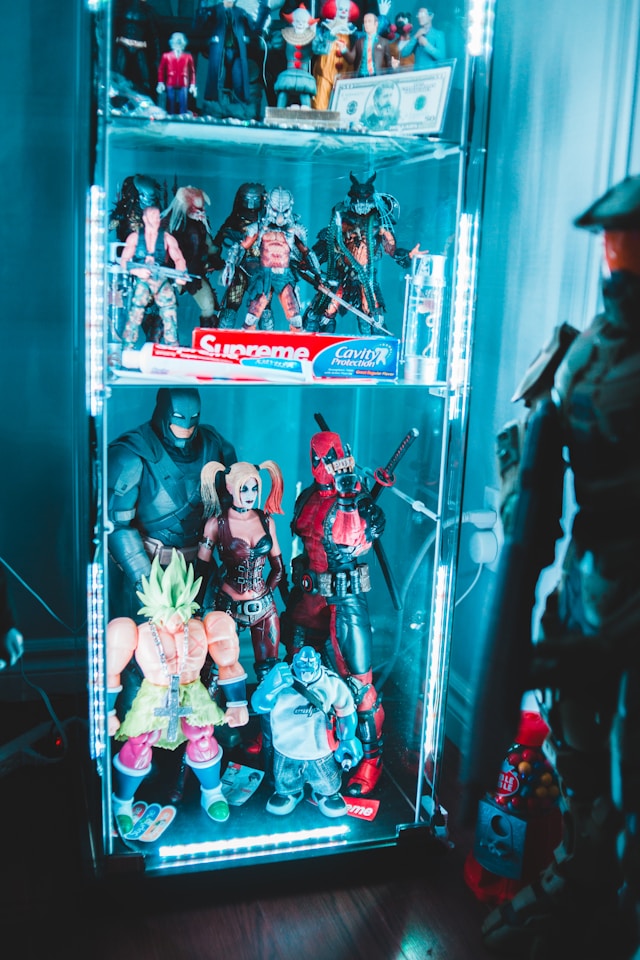 Uma prateleira cheia de bonecos colecionáveis da cultura pop, de Star Wars a Marvel.