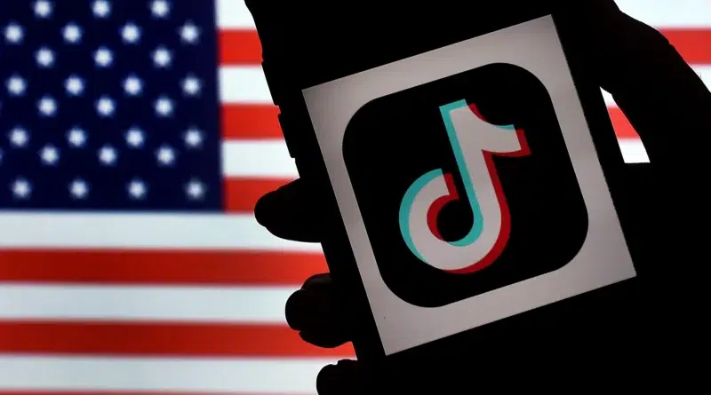 Acordo do TikTok nos EUA: imagem do app em iPhone sobre bandeira dos EUA; venda, segurança e algoritmo