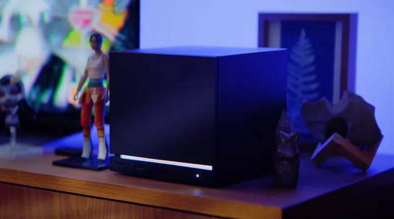 Steam Machine sobre mesa de madeira com luz branca na base, imagem de divulgação da Valve