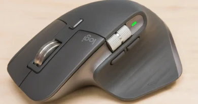 Mouse Logitech MX Master 3S sobre couro marrom, com botões prateados e logotipo Logi visível.