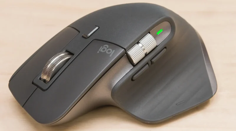 Mouse Logitech MX Master 3S sobre couro marrom, com botões prateados e logotipo Logi visível.
