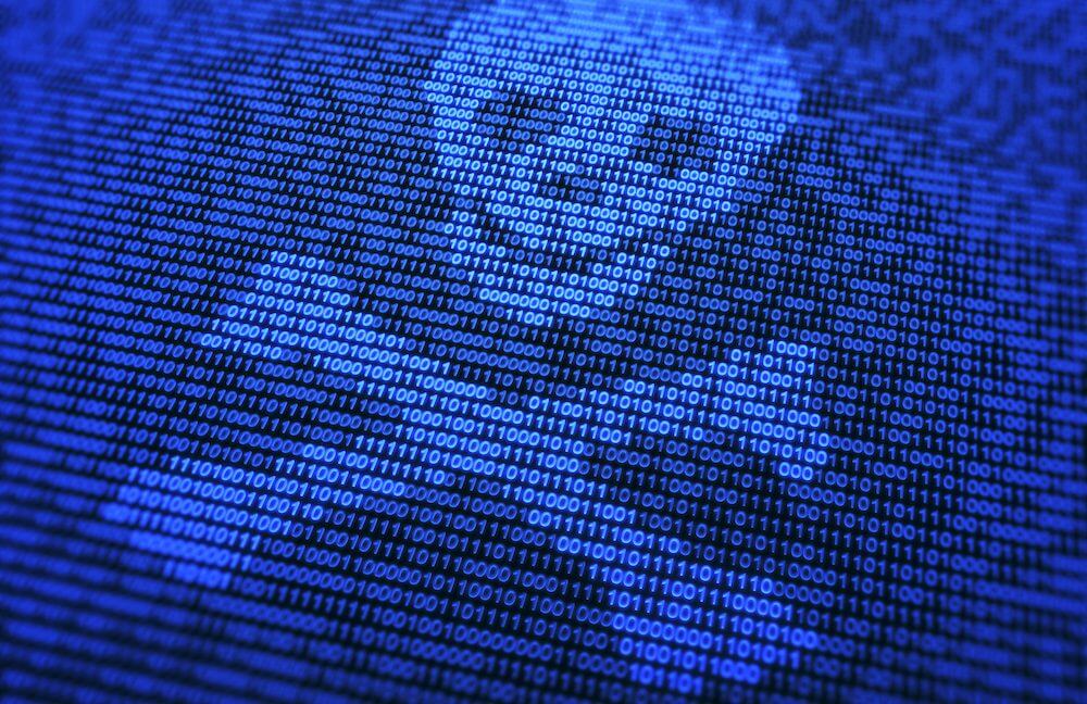 Uma caveira estilizada com ossos cruzados, feita de uns e zeros.