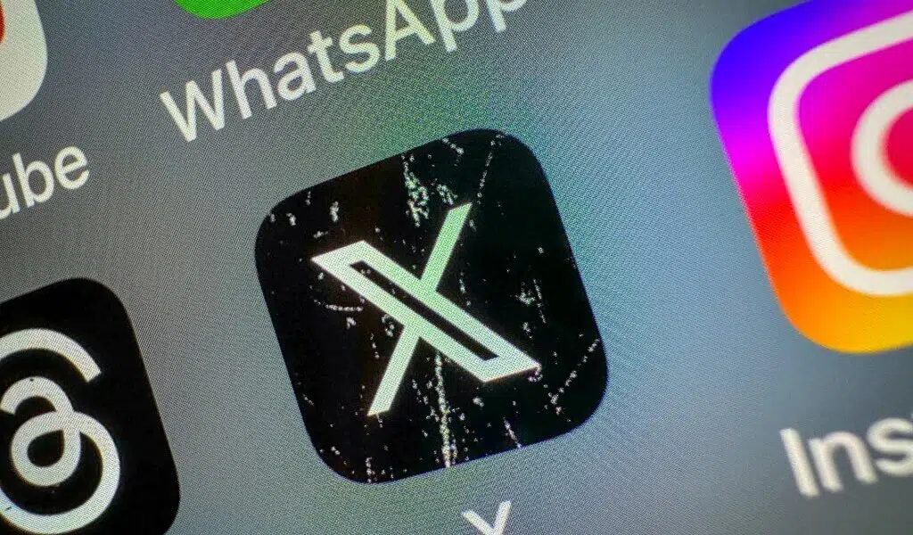 Imagem ilustrando o aplicativo X aberta em um smartphone, simbolizando debates sobre monetização e clickbait.