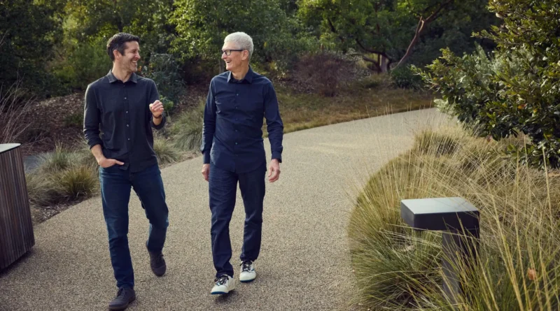 John Ternus e Tim Cook sorrindo e caminhando lado a lado.