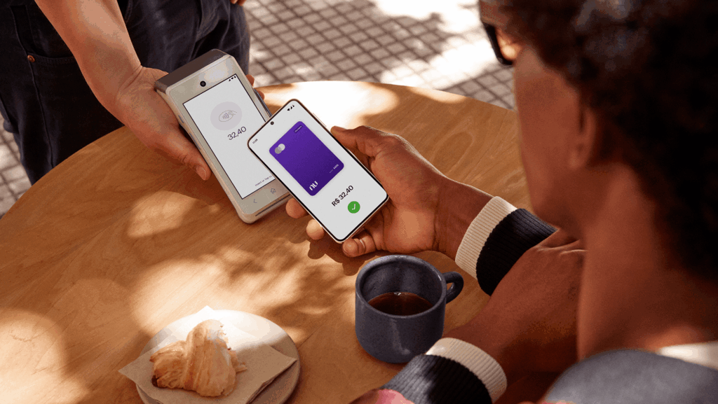 Nubank lança Pix por aproximação com débito e crédito integrados 3 Pessoa aproximando celular de maquininha de cartões para pagar com o Nubank